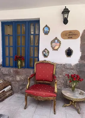 a red chair sitting next to a wall with a table at CASA CRISTOBAL Siete Cuartones in Cusco