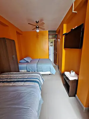 a hotel room with two beds and a flat screen tv at La Ruta in Paracas