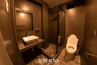 a bathroom with a toilet and a sink at Besso Beach Hotel in Barranca