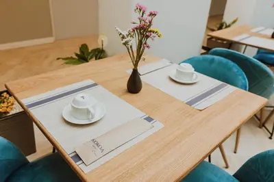 a wooden table with two plates and a vase with flowers at Kokoa Hotel Cusco in Cusco
