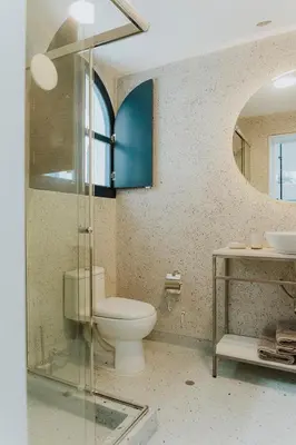 a bathroom with a toilet and a glass shower at Kokoa Hotel Cusco in Cusco