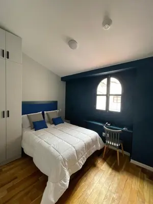 a bedroom with a large bed with a blue wall at Kokoa Hotel Cusco in Cusco