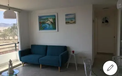 a living room with a blue couch and a window at Depa de Playa en Asia in Asia