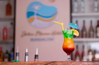a drink sitting on a table with an umbrella at Bungalow Jatun Mama in Ventanilla