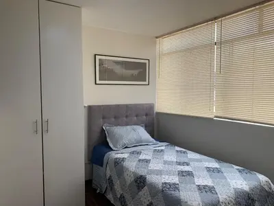 a bedroom with a bed and a window with blinds at Lindo departamento en Magdalena del Mar in Lima