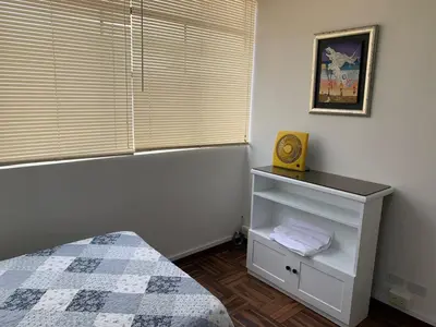 a bedroom with a bed and a window with a clock at Lindo departamento en Magdalena del Mar in Lima