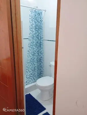a bathroom with a toilet and a shower curtain at Qente Wings in Ollantaytambo