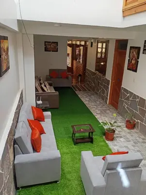 a living room with a couch and green grass at Qente Wings in Ollantaytambo