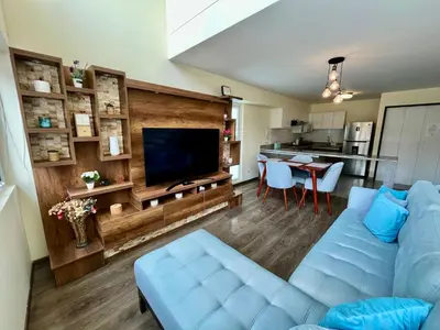 a living room with a blue couch and a television at Elegante Duplex Cerca Parque Kennedy Miraflores in Lima