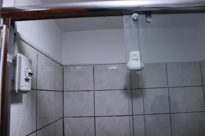 a shower in a bathroom with a phone on the wall at Hospedaje San Isidro 402 in Lima