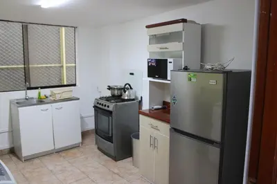 a kitchen with a stove and a refrigerator at Hospedaje San Isidro in Lima