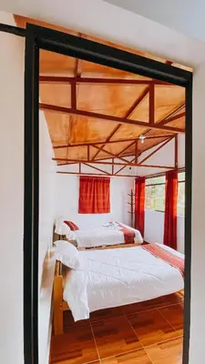 two beds in a room with red curtains at The Willow B&B in Urubamba