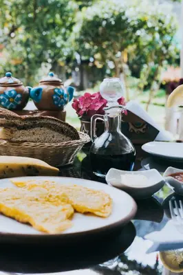 a table with a plate of food on a table at The Willow B&B in Urubamba