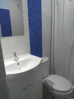 a bathroom with a white sink and a toilet at Chakana Family Home 2 Lima Airport in Lima