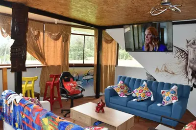 a living room with a blue couch and a tv at New Experiences Valle sagrado in Urubamba