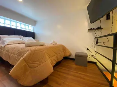 a bedroom with a large bed and a flat screen tv at Loft en centro histórico Cusco Inlove in Cusco