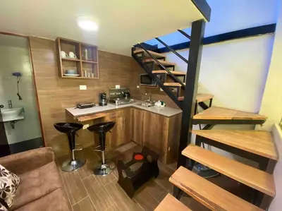 a small room with a kitchen and a staircase at Loft en centro histórico Cusco Inlove in Cusco