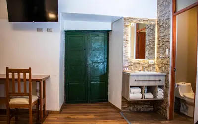 a bathroom with a green door and a sink at Estancia San Pedro Hotel in Cusco