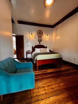 a bedroom with a bed and a blue couch at Terra Sagrada Cusco in Cusco