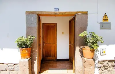 an open door with two potted plants in front of it at Terra Sagrada Cusco in Cusco