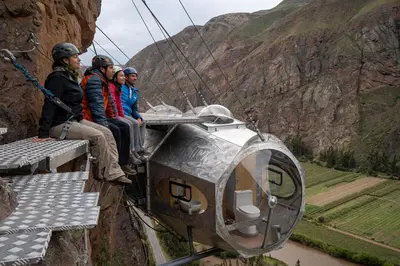 a group of people riding a gondola over a canyon at Starlodge Adventure Suites in Urubamba