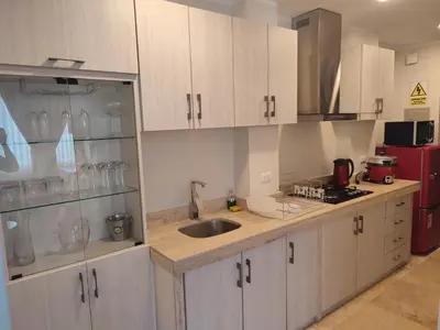 a kitchen with white cabinets and a sink at Chanka Suites in Talavera
