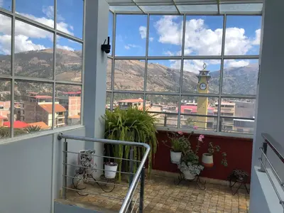 a balcony with potted plants and a clock tower at Chanka Suites in Talavera