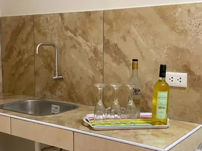 a kitchen counter with wine bottles and glasses on a tray at Residencia Benavides in San Vicente de Cañete