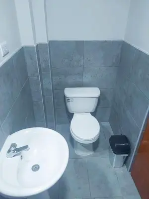 a bathroom with a white toilet and a sink at Residencia Benavides in San Vicente de Cañete