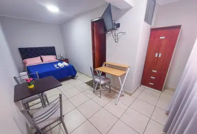 a small bedroom with a bed and a table and chairs at Residencia Benavides in San Vicente de Cañete