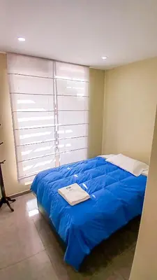 a large blue bed in a room with a window at Apartamento JATUN MAMA in Chancay