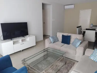 a living room with a couch and a tv at Apartamento JATUN MAMA in Chancay