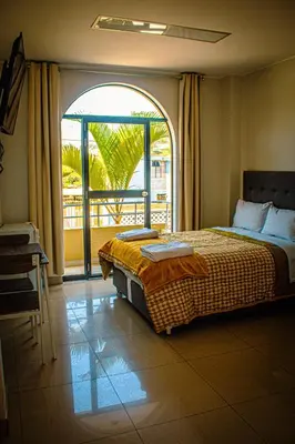 a bedroom with a bed and a large window at DEL VALLE HOUSE II in Ica