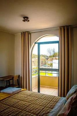 a bedroom with a bed and a large window at DEL VALLE HOUSE II in Ica