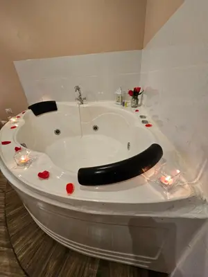 a bath tub with a black seat in a bathroom at Hotel La Colina in Ica