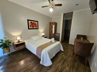 a bedroom with a bed and a ceiling fan at Hotel La Colina in Ica