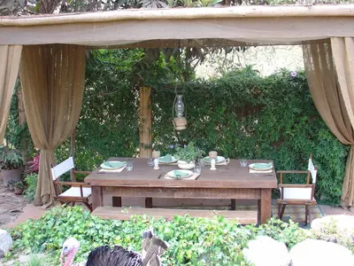 a wooden table and chairs in a garden at Villa Celestial in Nieve Nieve