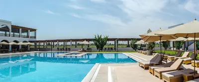 a large swimming pool with chairs and umbrellas at Hotel Viñas Queirolo in Ica