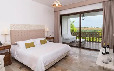 a bedroom with a white bed and a balcony at Hotel Viñas Queirolo in Ica