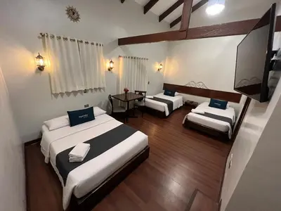 a large room with two beds and a television at Hotel Andina in Cusco