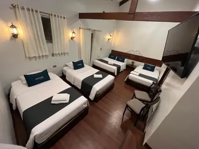 a group of four beds in a room at Hotel Andina in Cusco