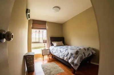 a small bedroom with a bed and a window at Apartamento 3 Habitaciones Lima, Perú (Magdalena del Mar) in Lima