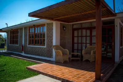 a patio with chairs and a wooden pergola at Casa Solaris in Ica