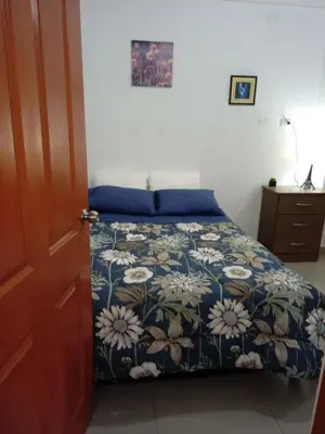 a bedroom with a bed with a blue and white bedspread at Departamento con servicios incluidos, equipado in Lima