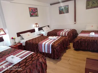 a hotel room with three beds in a room at DENNY'S MAPI in Machu Picchu