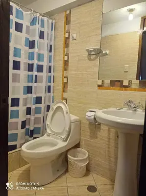 a bathroom with a toilet and a sink at DENNY'S MAPI in Machu Picchu