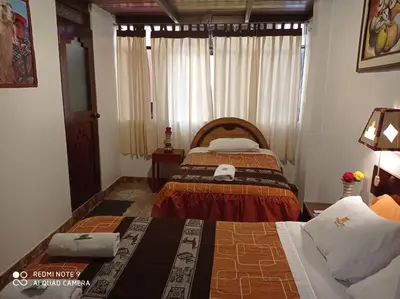 a bedroom with two beds and a window at DENNY'S MAPI in Machu Picchu