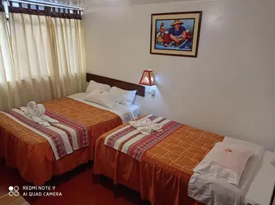 a hotel room with two beds and a picture on the wall at DENNY'S MAPI in Machu Picchu