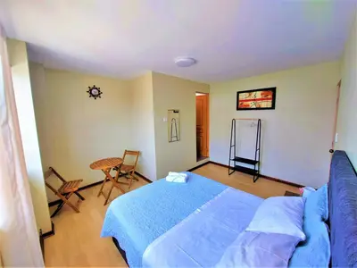 a bedroom with a bed and a table and a clock at Casa Mahulu in Paracas