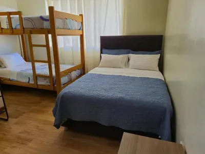 a bedroom with a bed and two bunk beds at Casa Mahulu in Paracas